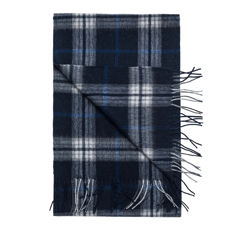 AMANDA CHRISTENSEN - CLASSIC CHECKED WOOL SCARF IN NAVY, a folded wool scarf in a classic navy blue checked pattern with grey and white accents and fringed edges.