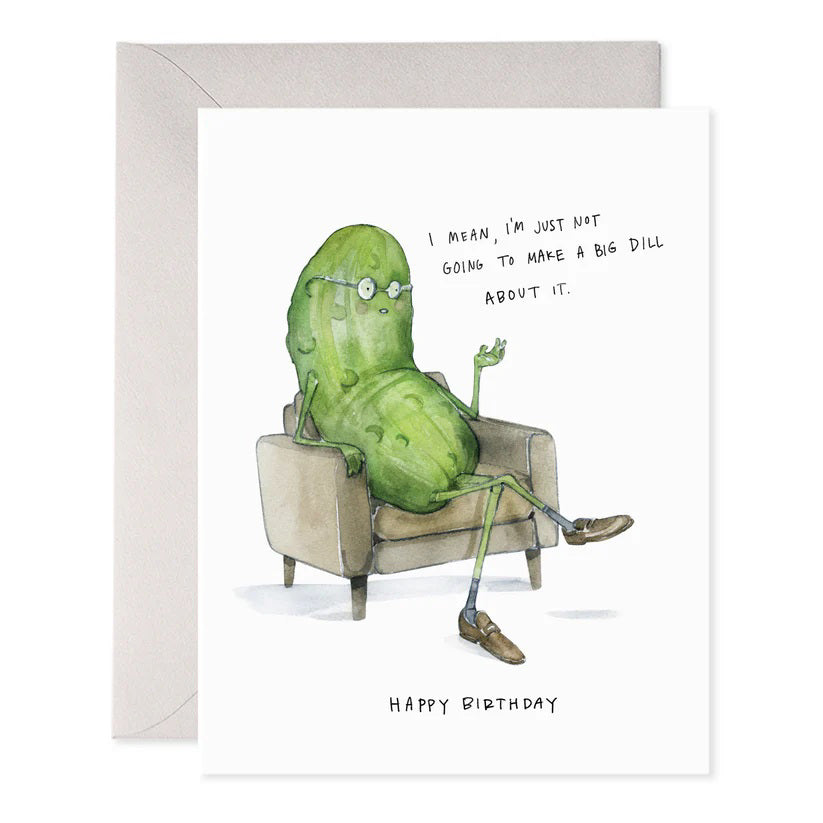 The E. FRANCES PAPER - BIG DILL GREETING CARD showcases a cartoon pickle with glasses, sitting cross-legged in an armchair, with the text: "I mean, I’m just not going to make a big dill about it. Happy Birthday." It's a charming whimsical card for any collection!.