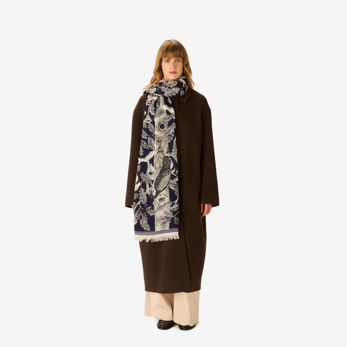 The INOUI EDITIONS - ARCHIMEDE WOOL SCARF IN NAVY by INOUI is crafted in India and features a detailed tree adorned with numerous birds and flowers on its branches, set against a white background.