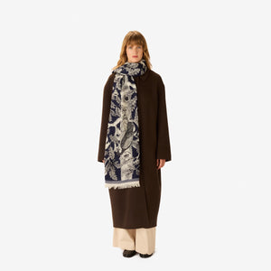 The INOUI EDITIONS - ARCHIMEDE WOOL SCARF IN NAVY by INOUI is crafted in India and features a detailed tree adorned with numerous birds and flowers on its branches, set against a white background.