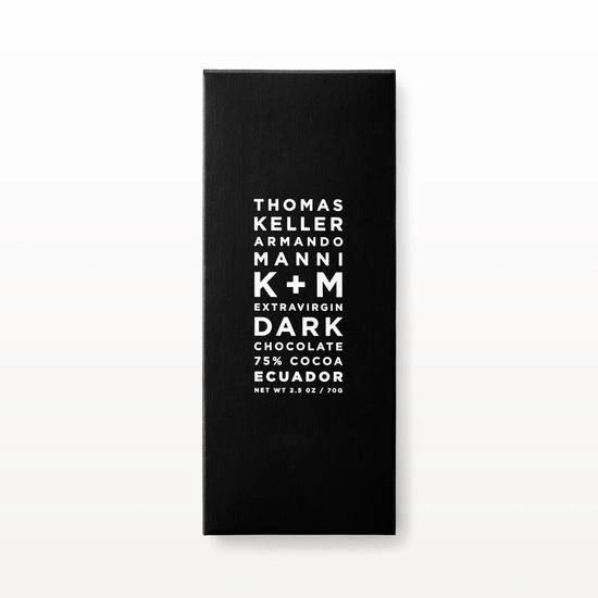 A black rectangular chocolate bar wrapper with white text that reads: "K &amp; M EXTRAVIRGIN CHOCOLATE K+M Extra Virgin Dark Chocolate 75% Cocoa Ecuador Net Wt 3.5 oz / 70g," highlighting its rich antioxidants and low acidity.