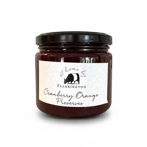The Fearrington Housemade Cranberry Orange Preserves from the Fearrington Signature Collection, featuring a white label, are perfect breakfast jams. Made with cranberries, orange zest, cinnamon, sugar, port, and pectin by Fearrington chefs, they make an ideal handmade hostess gift. Allergen info is on the label.