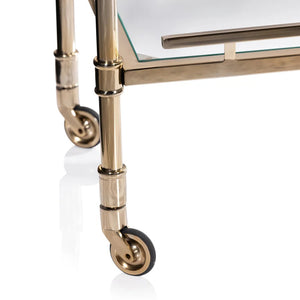 The SPIGA GOLD BAR CART by ZODAX features a vintage Italian-inspired design with elegant gold framing, mirrored glass shelves on both tiers, and smooth-rolling four-wheel mobility. Displayed against a white background, this piece is both stylish and functional.