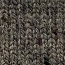 Close-up of gray, ribbed knit fabric with a vertical pattern. The yarn texture and individual stitches are clearly visible, highlighting the soft and cozy feel of the AUTUMN CASHMERE Milano Stitch Shacket in Grizzly—a luxury shirt jacket expertly crafted for both comfort and style.
