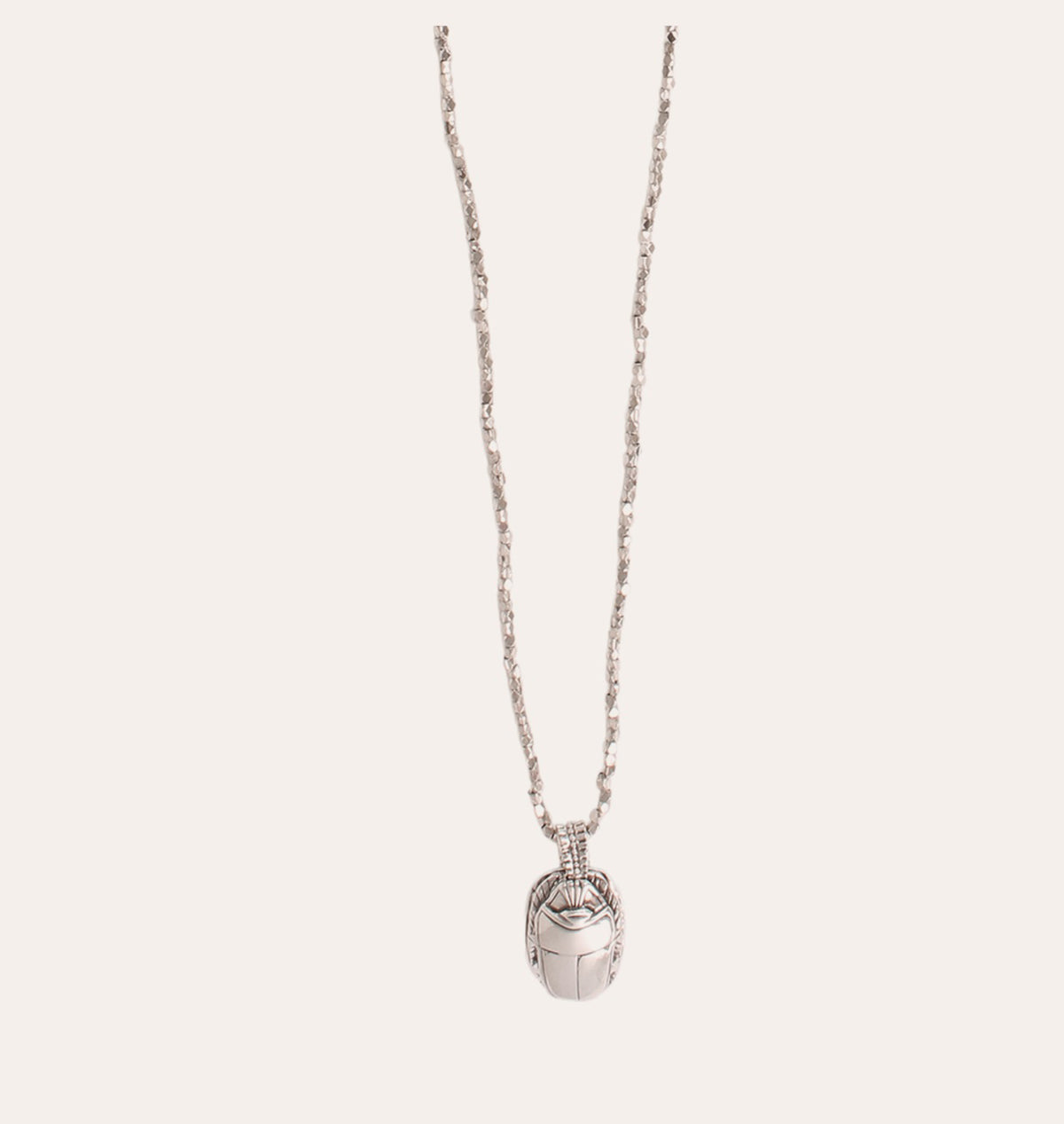 The GAS BIJOUX - LUCKY SCARABEE LONG SILVER NECKLACE showcases a delicately hand-engraved scarab pendant with exquisite details. Its chain is slender and textured, providing an adjustable length for versatile styling. The jewelry is elegantly highlighted against a soft, light-colored background.