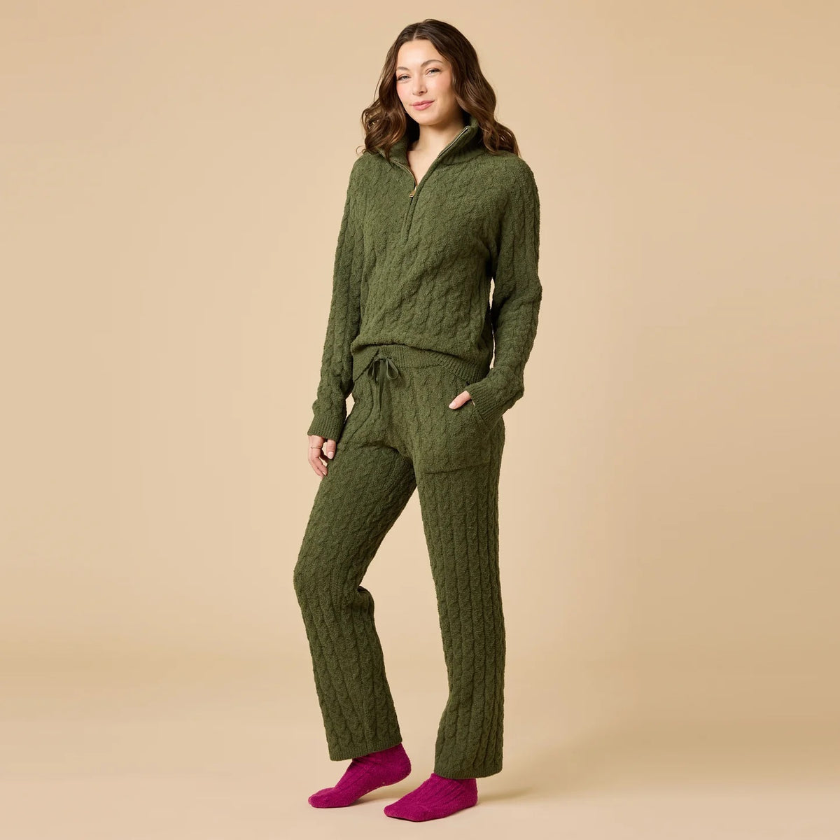 A woman wearing a marshmallow-soft, cream-colored SOFTIES - CABLE KNIT MARSHMALLOW ½ ZIP WITH TAPERED PANT SET, featuring a half-zip pullover and matching pants with a drawstring waist.