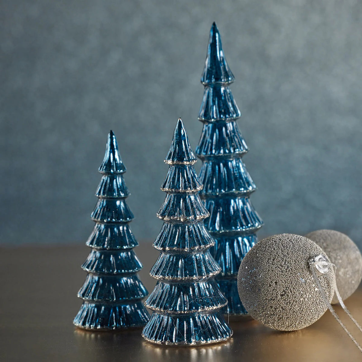 The ZODAX VERBIER LED Glass Tree in blue with silver trim, a small and shiny ornament, stands upright on a plain white background and features a built-in LED light.