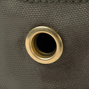 A person wearing the TILLEY - ICONIC T1 BUCKET HAT IN OLIVE with yellow eyelets and a white crew-neck shirt looks slightly to the side against a plain light background. The TILLEY hat offers UPF 50+ sun protection.