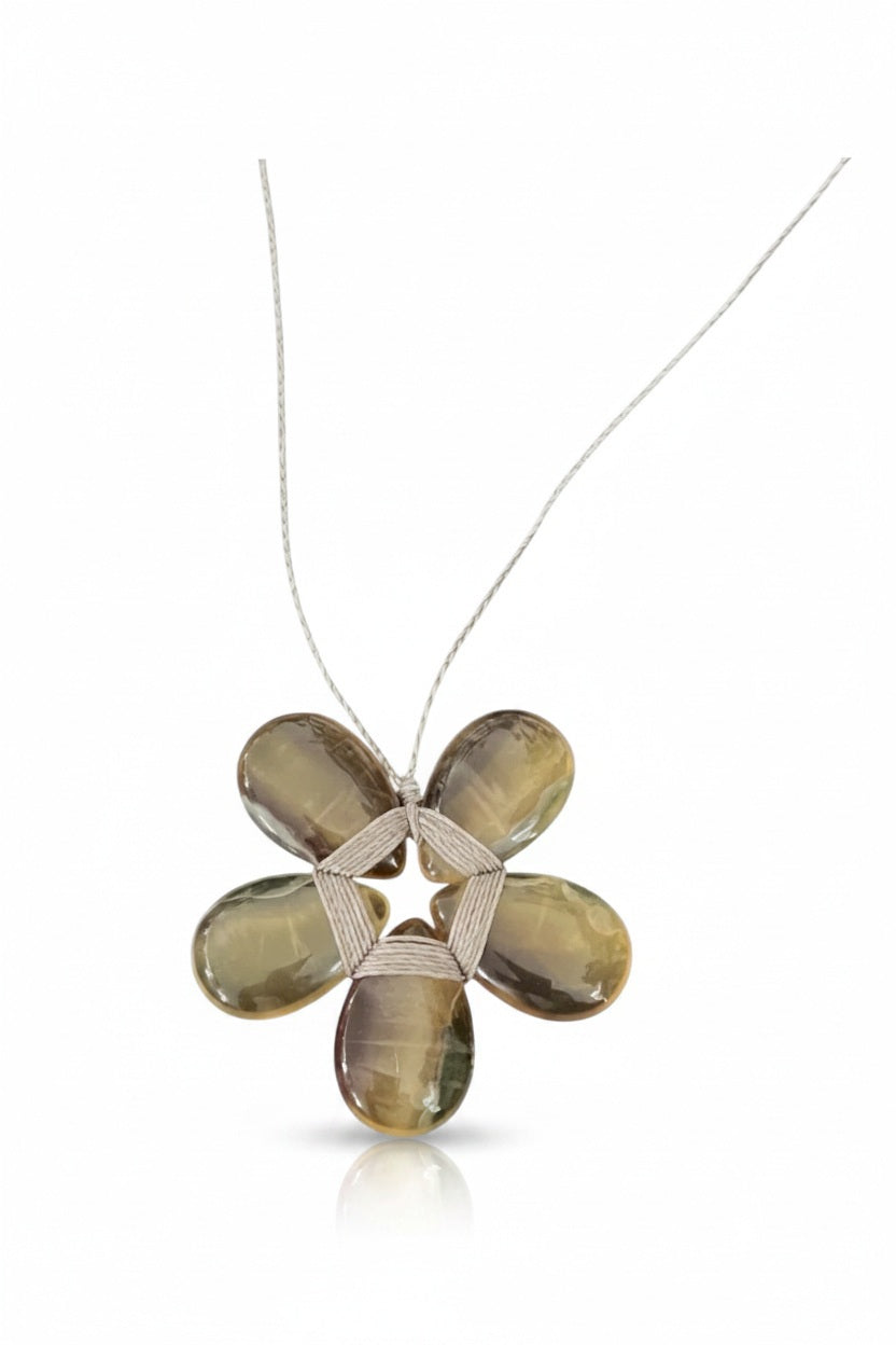 The ANN LIGHTFOOT - FLOURITE FLOWER NECKLACE by ANN LIGHTFOOT showcases a delicate blossom-shaped pendant with five oval, translucent fluorite stones forming the petals and detailed wire wrapping in the center. Suspended from a slim chain against a white background, this elegant piece makes a refined statement for any occasion.