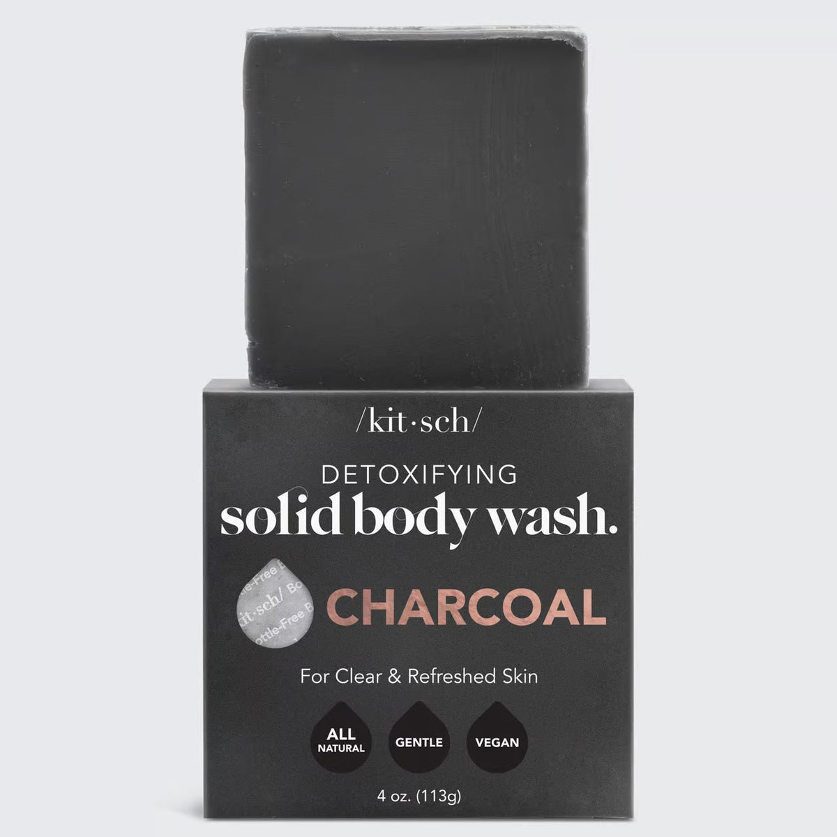 The KITSCH - CHARCOAL DETOXIFYING BODY WASH BAR, a black square solid soap on a matching box, is gentle, vegan, and all-natural. Detoxify pores and refresh your skin with this 4 oz. (113g) zero-waste treat while embracing an eco-friendly lifestyle.