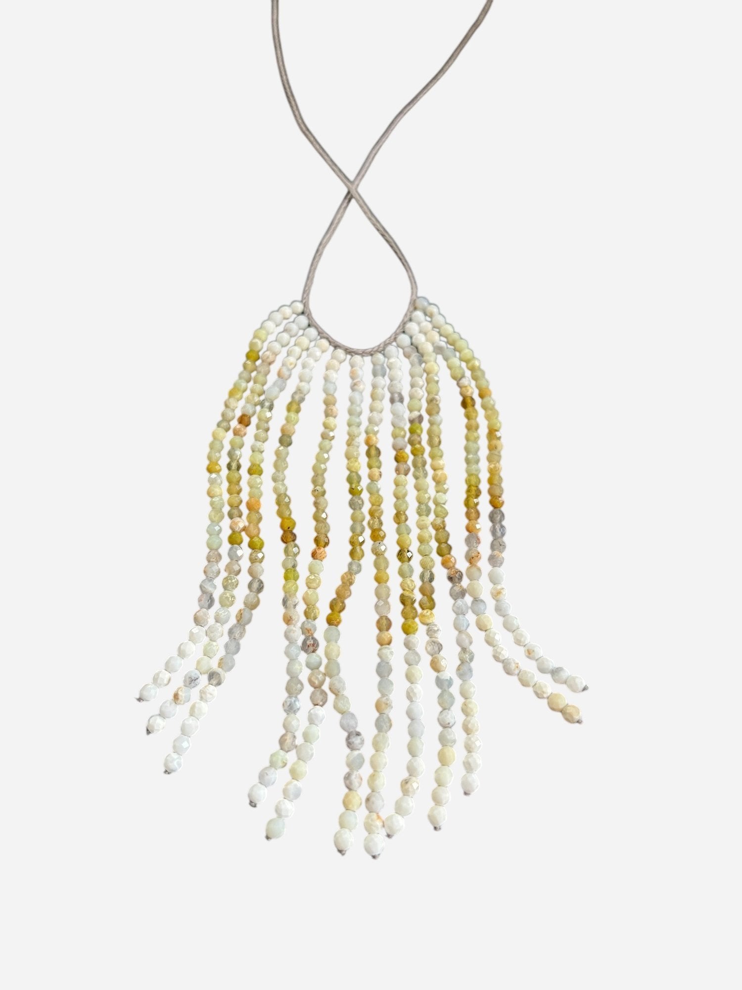 The ANN LIGHTFOOT Ombre African Opal Cascade Necklace features strands of small, faceted beads in yellow, white, and gray on a thin, light-colored cord for a fringe-like design.