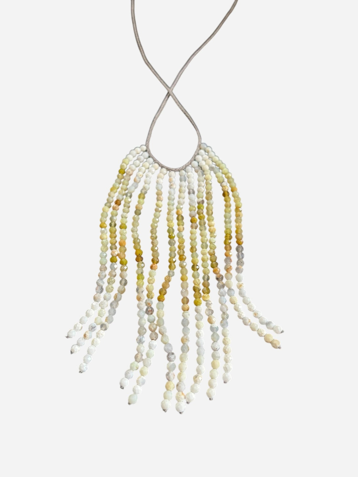 The ANN LIGHTFOOT Ombre African Opal Cascade Necklace features strands of small, faceted beads in yellow, white, and gray on a thin, light-colored cord for a fringe-like design.