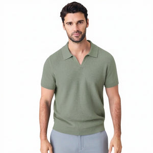 A man with short dark hair is seen from behind wearing the MACK WELDON Tech Linen Johnny Collar Polo Sweater in Sage Leaf Heather, paired with light gray pants against a plain light gray background.