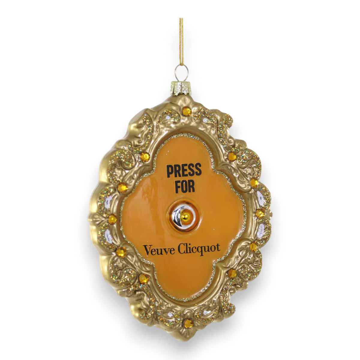 The PRESS FOR FRENCH CHAMPAGNE ORNAMENT by CODY FOSTER features gold and orange tones, jeweled accents, a center button labeled &quot;PRESS FOR Veuve Clicquot,&quot; and hangs from a gold string—ideal for gifting, collectors, or design lovers.