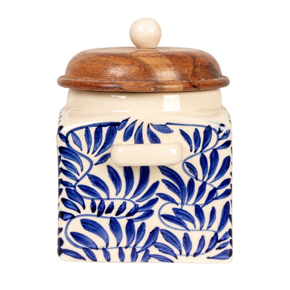 A close-up of the CREATIVE COOP HAND-PAINTED STONEWARE CANISTER WITH LID AND SPOON shows blue floral designs on cream stoneware and an acacia wood lid—an elegant farmhouse kitchen accent.