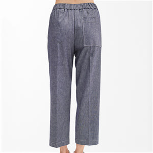 A person wearing the MEIMEIJ - DENIM COTTON PULL ON PANT in high-waisted, blue-gray denim with an elastic waistband, pocket detail, and relaxed, cropped legs stands against a plain white background. Only the pants and lower torso are visible.