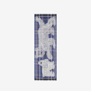 The INOUI FREDDY DOG SCARF IN 3D BLUE by INOUI is a rectangular, blue plaid wool-cotton scarf featuring white sketch-like dog drawings and fringed edges on both short sides, made in India.