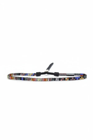 The JULIE ROFMAN - MINI BRACELET by JULIE ROFMAN JEWELRY is a vibrant handwoven piece adorned with small, square beads in various shades of pink, red, and white. It is displayed against a white background and includes a straightforward sterling silver clasp for convenient fastening.