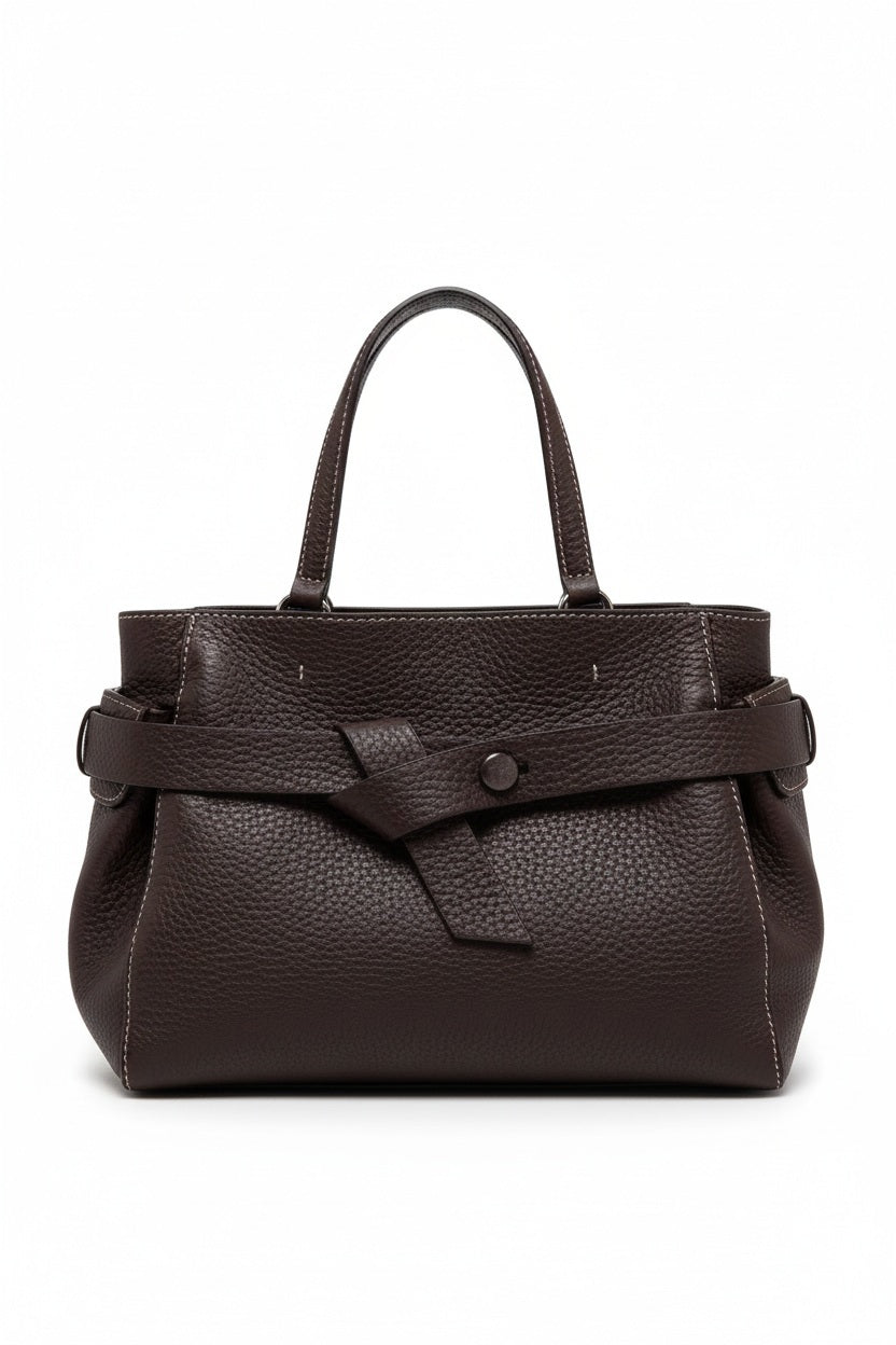 The GIANNI CHIARINI - MIRANDA HANDBAG IN ESPRESSO is a dark brown handbag crafted from pebbled, hammered leather, featuring two handles and a distinctive knotted strap detail across the front. It comes finished with a removable shoulder strap and is shown against a white background.