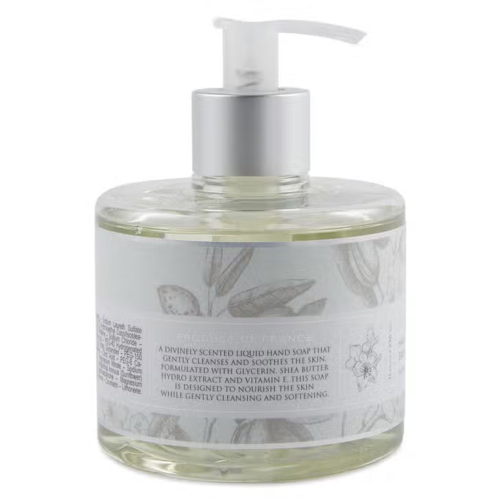 A pump bottle of HERITAGE LIQUID SOAP - HONEY ALMOND by EUROPEAN SOAPS, LLC. Infused with shea butter and glycerin, the label features illustrations of flowers and almonds, with text in English and French. The bottle contains 11.8 fluid ounces (350 milliliters) of liquid soap.