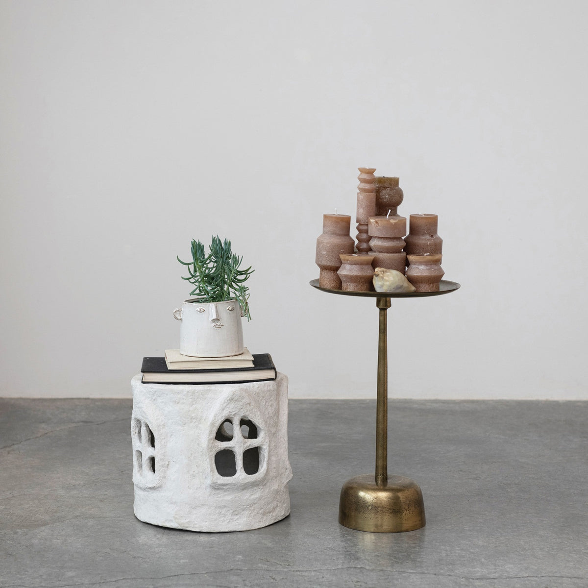 The CREATIVE COOP ALUMINUM SIDE TABLE WITH ANTIQUE BRASS FINISH is a small, round piece showcasing a wide, shallow top, slender central stem, and rounded base. Set against a plain white background, this modern minimalist table features an elegant aluminum construction with an antique brass finish.