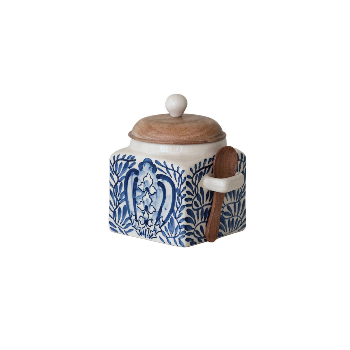A close-up of the CREATIVE COOP HAND-PAINTED STONEWARE CANISTER WITH LID AND SPOON shows blue floral designs on cream stoneware and an acacia wood lid—an elegant farmhouse kitchen accent.