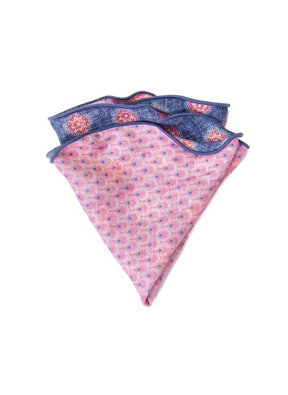 The EDWARD ARMAH Silk Reversible Pocket Circle Denim Foulard features a pink side with blue and red dots, a blue side with red and white geometric designs, and dark blue trimmed edges.