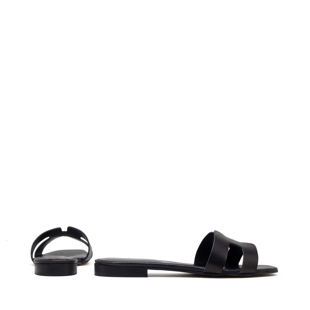 The image depicts the MICHELE LOPRIORE - H SLIDE, a single brown leather slide sandal with an open-toe design. The upper features two wide straps with geometric cutouts. The thin sole appears to be made of light brown wood-like material. Made in Italy by MICHELE LOPRIORE, the sandal is displayed against a plain white background.