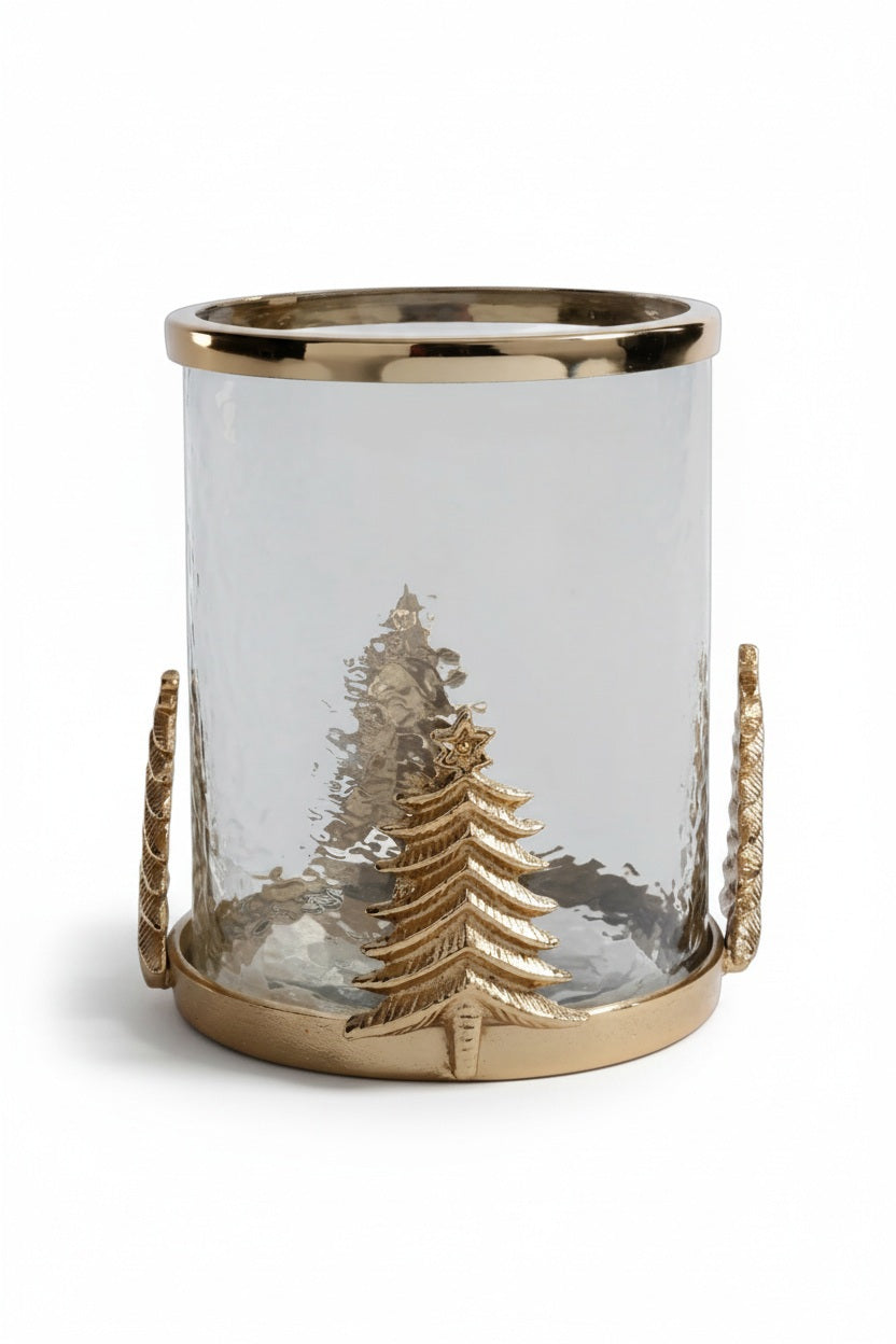 ZODAX GLASS AND ALLOY HURRICAN IN GOLD featuring a clear cylindrical glass and steel hurricane lamp with a gold-toned base, rim, and decorative gold Christmas tree embellishments on the sides.