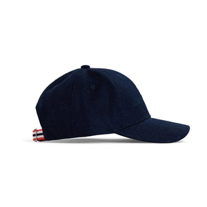 The AMUNDSEN SPORTS - WOOL CAP is a dark brown wool cap with a curved brim, subtle front embroidery, Norwegian design touches, and an adjustable strap, shown on a white background.