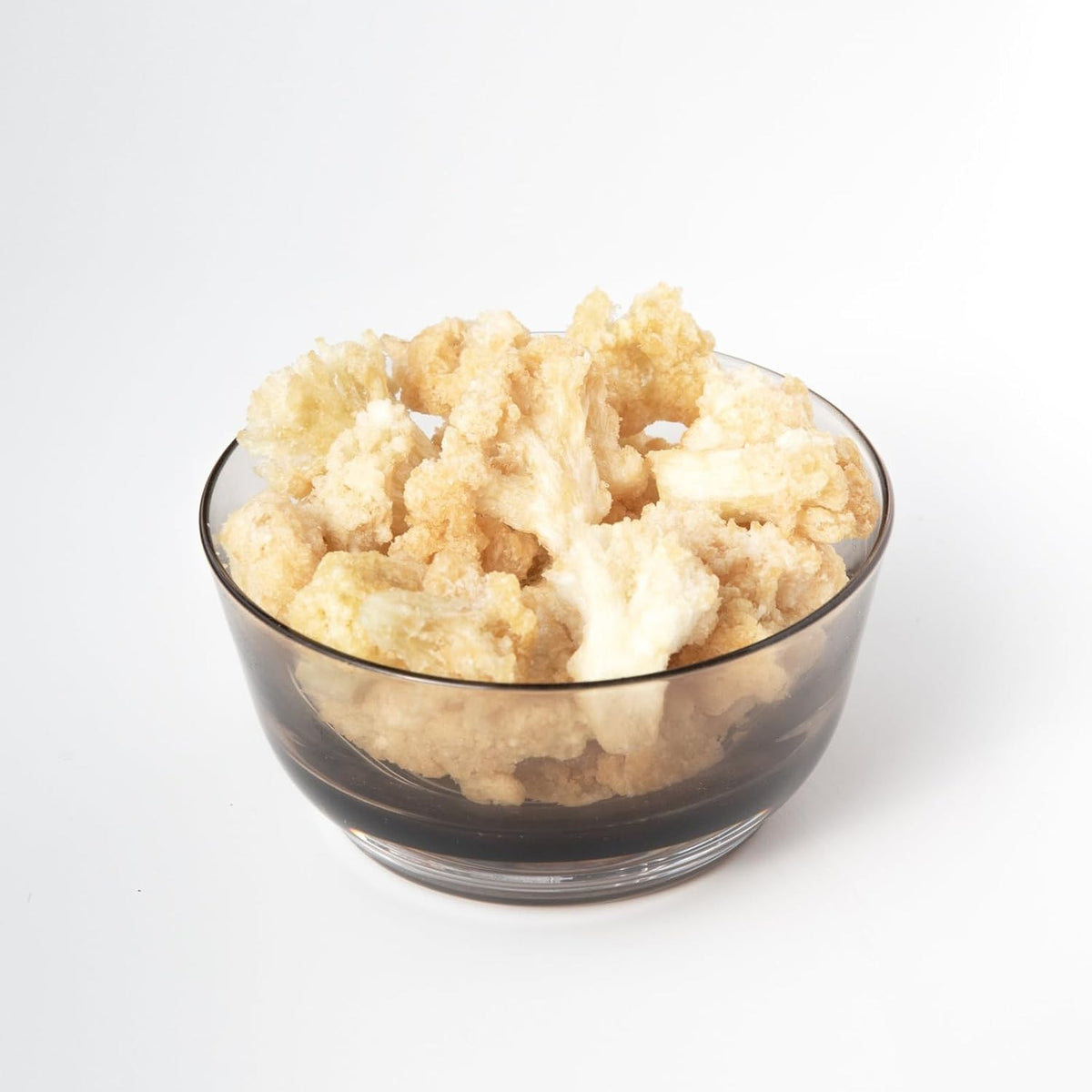A blue bag labeled “ROOT FOODS - CAULIFLOWER CHIPS” from the brand ROOT FOODS features an image of cauliflower. The packaging displays gluten-free, vegan, and non-GMO labels, highlighting these cauliflower chips as a tasty and healthy snack option.