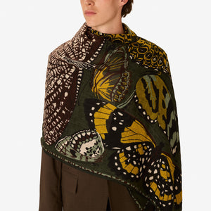 The INOUI EDITIONS - PAPILLONS SCARF IN KHAKI by INOUI is a rectangular linen scarf hand-printed with yellow, white, green, and black butterflies on a dark green background—perfect for elevating your khaki scarf collection.