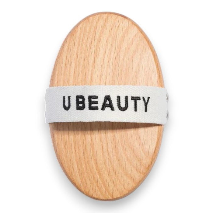 THE DRY BODY BRUSH by U BEAUTY features an oval wooden design with dense, light bristles, perfect for dry brushing and exfoliating to enhance your skin cleansing routine.