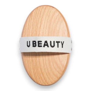 THE DRY BODY BRUSH by U BEAUTY features an oval wooden design with dense, light bristles, perfect for dry brushing and exfoliating to enhance your skin cleansing routine.