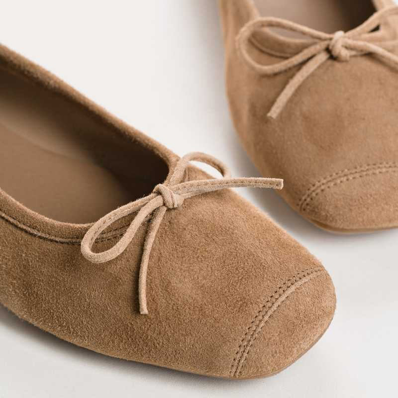 Top view of the REQINS - HARMONY SUEDE BALLERINA FLAT IN NATURAL, featuring a square toe and elegant bow detail—classic women's footwear by REQINS on a simple light background.