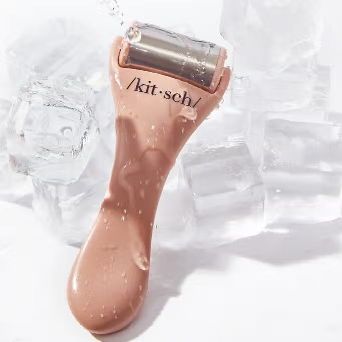 The beige packaging of the &quot;KITSCH - ICE FACE ROLLER,&quot; featuring surgical stainless steel, suits sensitive skin. Made from recycled plastic, circular icons on it emphasize benefits like enhanced blood circulation.
