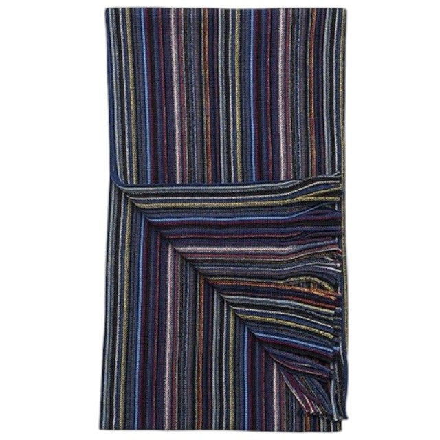 The AMANDA CHRISTENSEN Multi-Stripe Knitted Wool Scarf in Blue, featuring fringe at one end and bold multicolored stripes, is displayed folded against a plain white background.