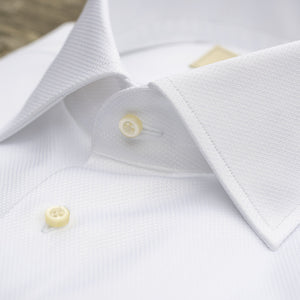 A crisp white HAGEN formal dress shirt in Italian cotton dobby, featuring a pointed collar, French cuffs, and the "HAGEN" label inside the collar.