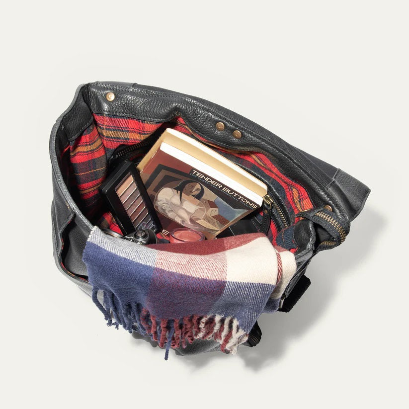 The WILL LEATHER GOODS OTTO Crossbody Bag in black full-grain leather features a front flap, gold-tone hardware, adjustable shoulder strap, and a small stitched patch on the lower right corner. Displayed against a plain white background.