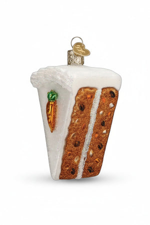 An OLD WORLD CHRISTMAS CARROT CAKE ORNAMENT shaped like a slice of carrot cake with white cream cheese icing and a small carrot decoration, hanging on a Christmas tree.