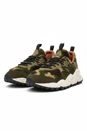 The FLOWER MOUNTAIN - KOKETSU SNEAKER by FLOWER MOUNTAIN/FALC USA features a chunky white speckled sole, olive and tan camo teddy-effect upper, black laces and pull tabs, plus an anatomical cork insole, shown on a plain light background.