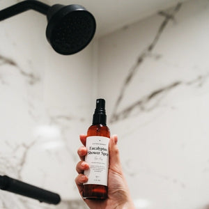A brown spray bottle labeled “SPA DAY EUCALYPTUS SHOWER SPRAY” from GIFTEN MARKET, featuring a black spray top and white label, contains an essential oil blend designed for aromatherapy use.