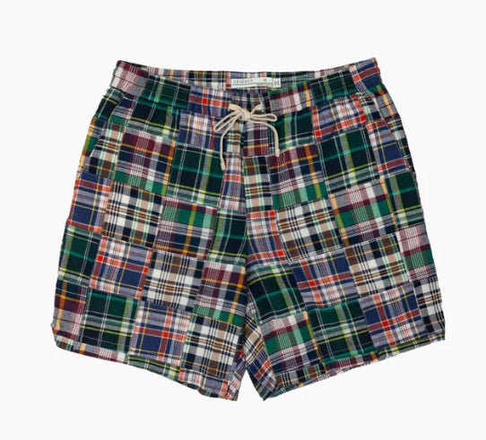 The CRIQUET Cruiser Shorts in Navy Madras feature a colorful plaid patchwork, elastic waistband with white drawstring, and are crafted from 100% cotton for comfort and style.