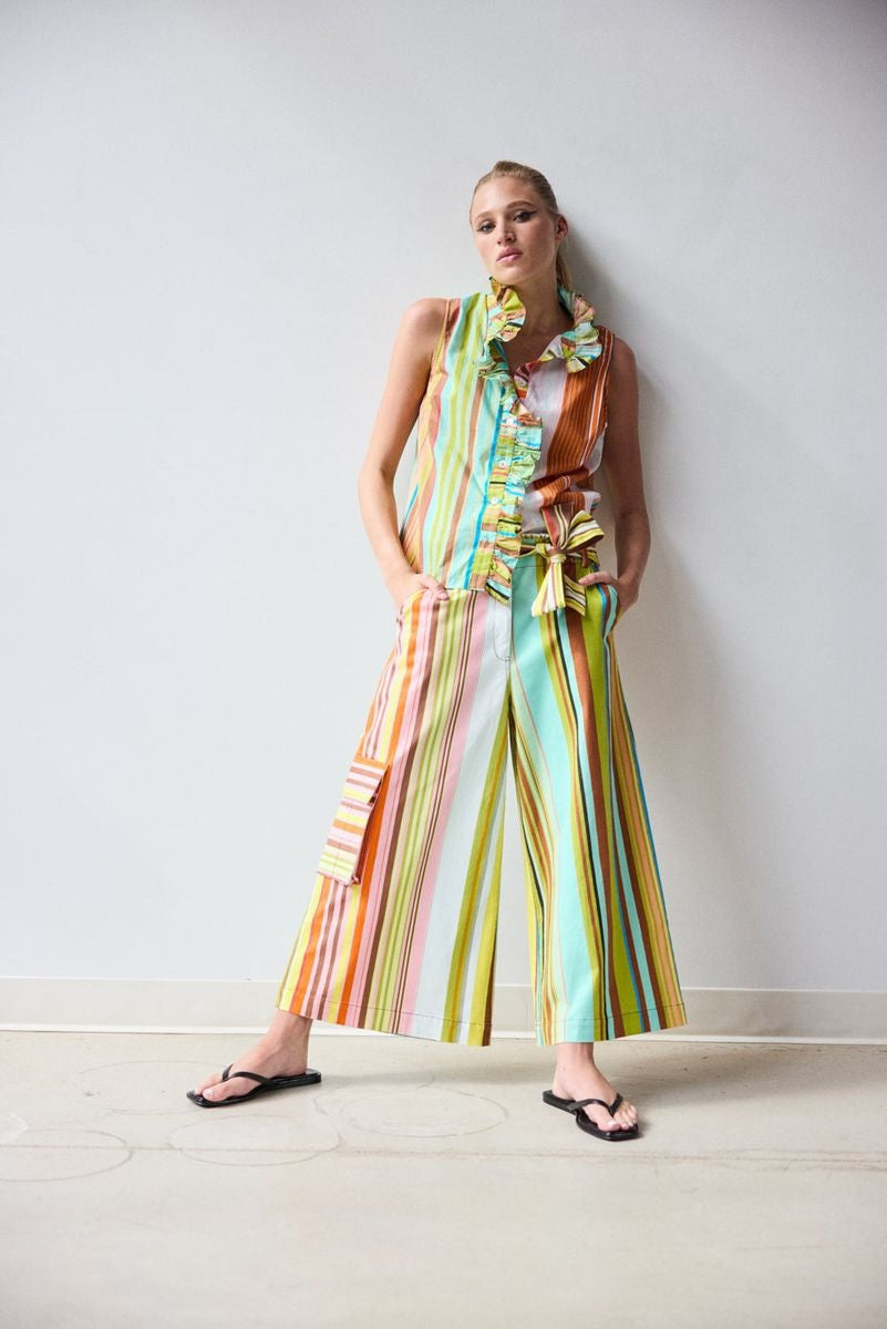 A person, seen from the back with hands on hips, wears the HOPE FOR FLOWERS - CROPPED PANT IN COMBO STRIPES: a colorful, striped matching set featuring wide leg cropped pants by HOPE FOR FLOWERS.
