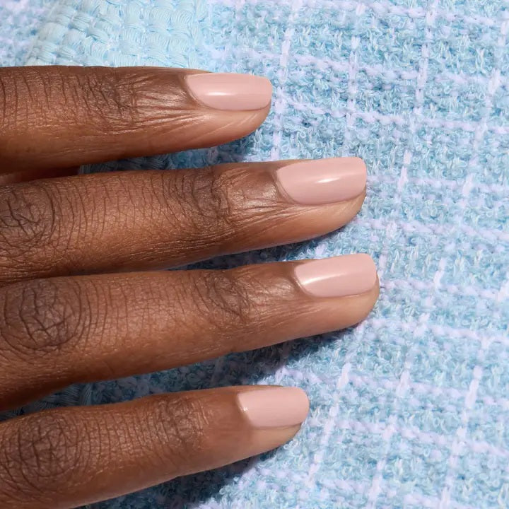 A bottle of MANUCURIST INC’s GREEN™ Nail Polish in Shell Beige, presented in a square glass bottle with a black cap and a white label displaying green and beige text. This non-toxic pinky beige polish combines elegant color with a clean, vegan formula.