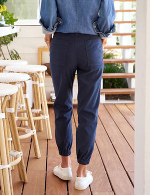 Introducing the FRANK & EILEEN JAMESON UTILITY JOGGER IN PERFORMANCE LINEN NAVY: a pair of high-rise jogger cargo pants crafted from textured Italian Performance Linen in a deep navy hue. These stylish joggers feature two front utility pockets, two large side pockets, an elastic waistband with belt loops, and elastic cuffs at the ankles. The pants are displayed on a plain white background.