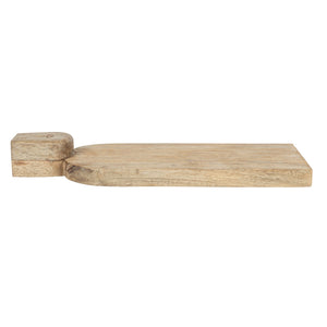 The CREATIVE COOP HAND-CARVED MANGO WOOD CHARCUTERIE/CUTTING BOARD WITH FACE HANDLE features a flat, rectangular shape, rounded edges, and rustic grain patterns for a handcrafted look.