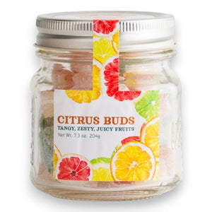 A clear mason jar with a silver lid containing colorful, citrus-flavored hard candies. The label reads "BUTTERFIELDS - CITRUS BUDS" and "Tangy, Zesty, Juicy Fruits" with illustrations of oranges, lemons, and grapefruits. The jar's net weight is 7.3 oz (204 g).