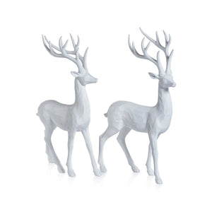The ZODAX ALL WHITE DECORATIVE DEER features two resin deer sculptures with smooth, faceted textures, resembling carved wood. Each measures 8.5 x 13.75 inches and is perfect for display on any white background.