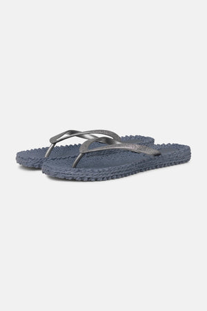 A pair of "CHEERFULL Flip Flops in Grey" by Lines of Denmark, featuring textured soles with dark blue straps, a slight shimmer, and a woven design on the footbed for enhanced comfort, are displayed against a plain white background.
